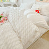 A white lightweight seersucker duvet cover set displayed on a bed with white pillows and a teddy bear.