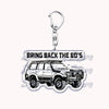 A silver metal key ring attached to a miniature model of a white off-road truck.