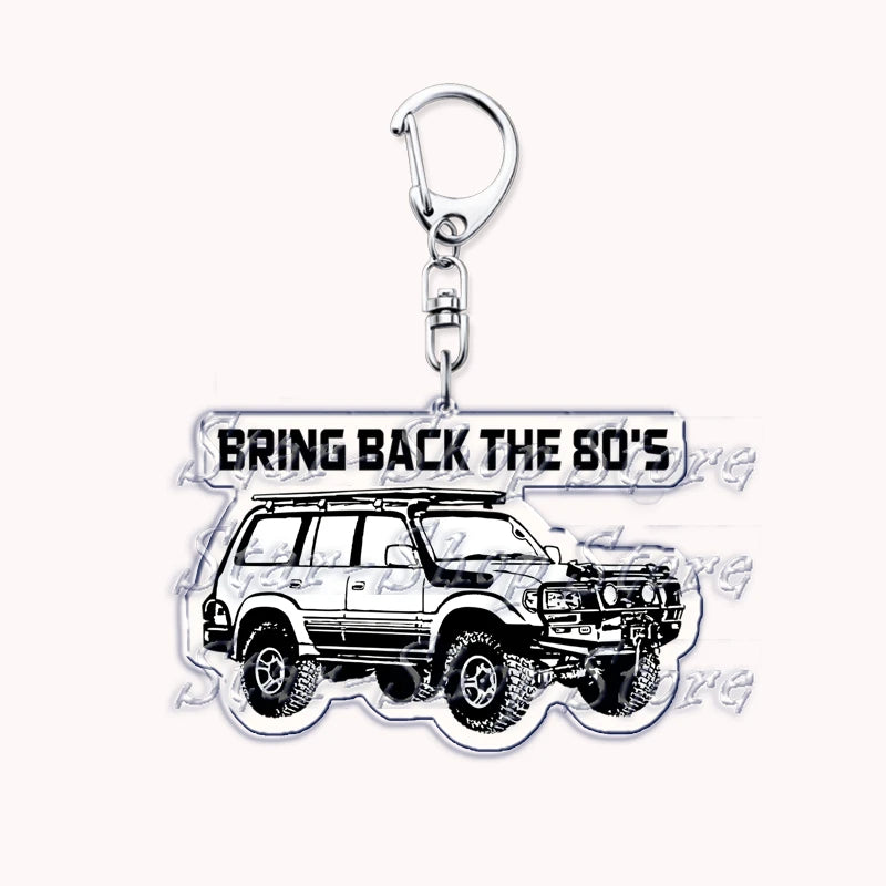 A silver metal key ring attached to a miniature model of a white off-road truck.