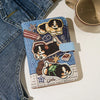 A blue and white cartoon dog leather passport holder with a light blue strap resting on a white surface.