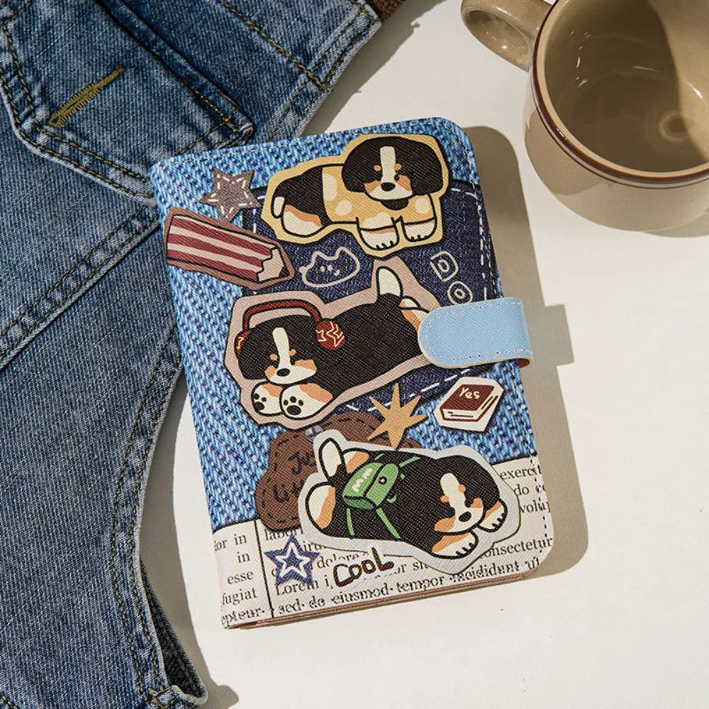 A blue and white cartoon dog leather passport holder with a light blue strap resting on a white surface.