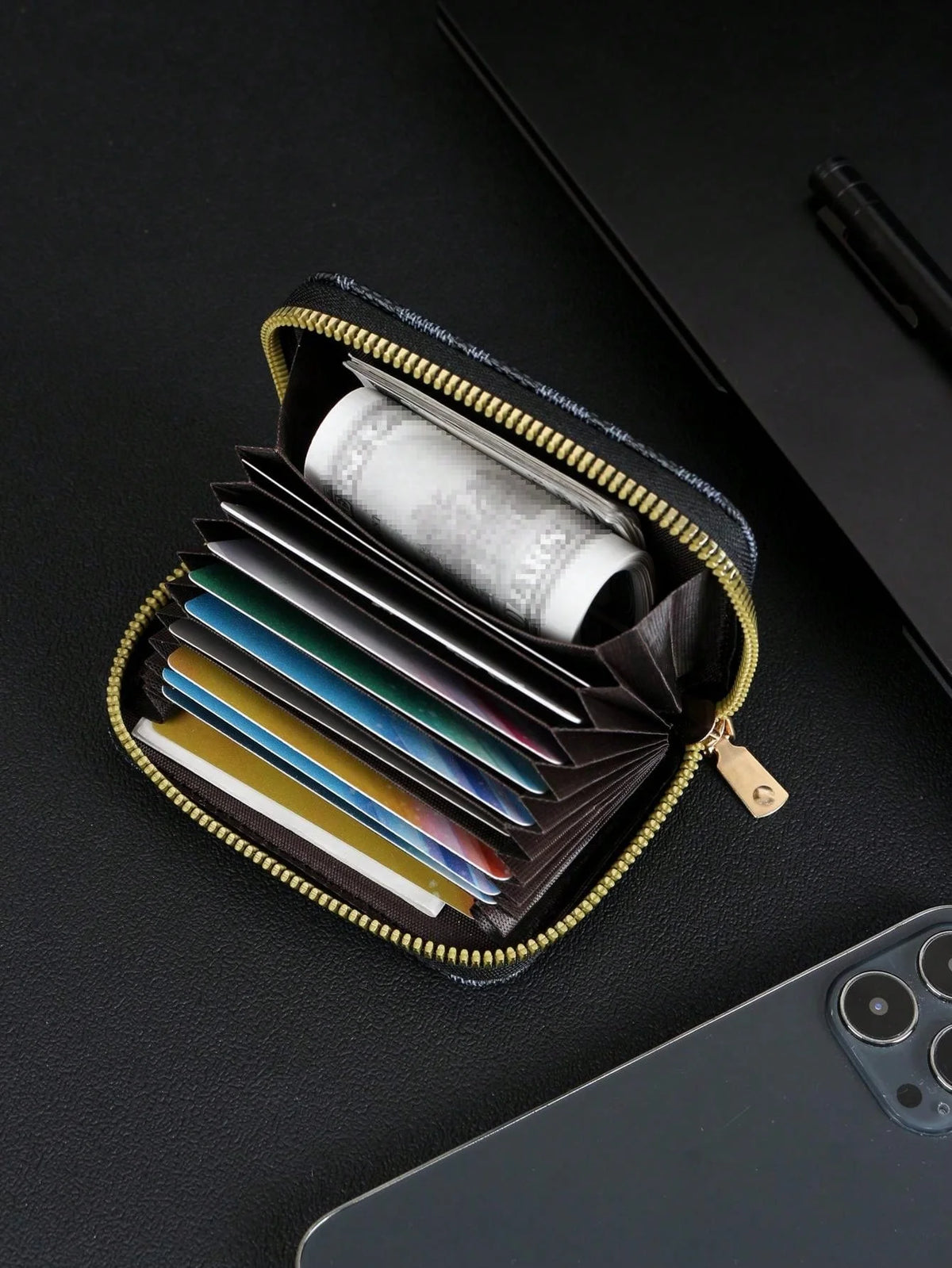 A black zippered card holder wallet is open, displaying several credit cards and a roll of cash inside.