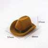 A tan felt cowboy hat with a dark band and gold accents, shown from the side.