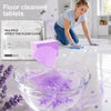 A glass bowl filled with purple cleaning tablets and soapy water on a glossy floor.