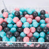 A large quantity of colorful plastic ball pit balls in shades of pink, blue, and gray are displayed in a white wire basket.