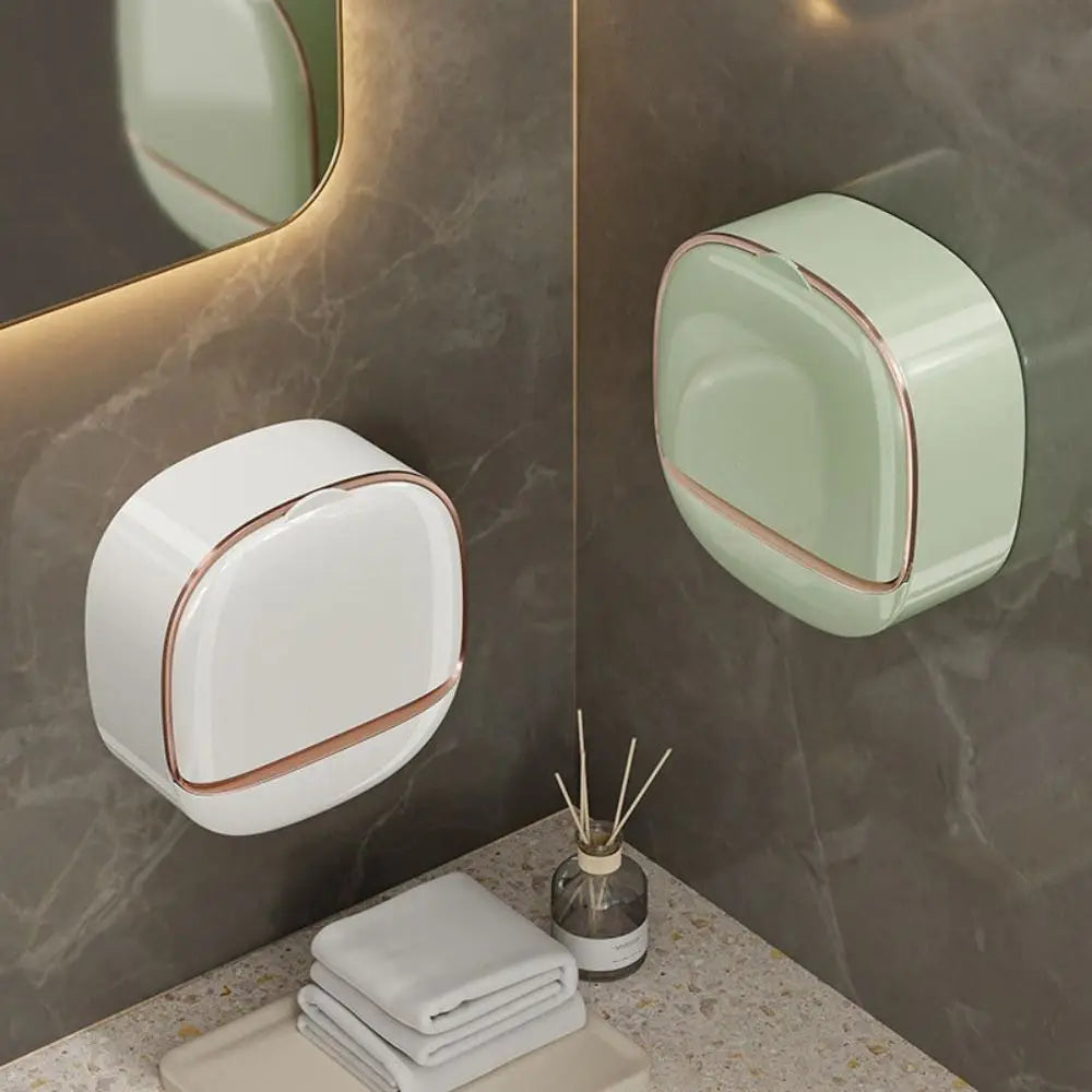 A light green wall mounted soap dish with a rounded design is displayed on a marble surface.