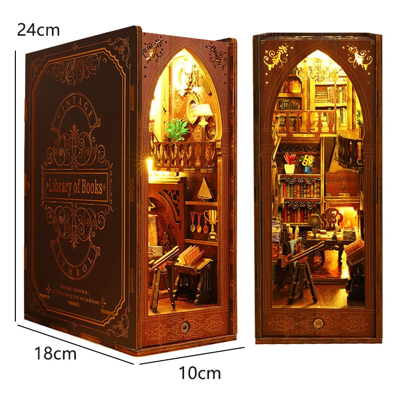 A wooden DIY book nook kit featuring a detailed miniature bookshelf room scene with an arched window and various decorative e