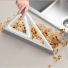 A hand is using a silicone squeegee broom to clean dried dirt from a surface.