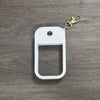White silicone protective case for a hand sanitizer spray attached to a gold-colored keyring