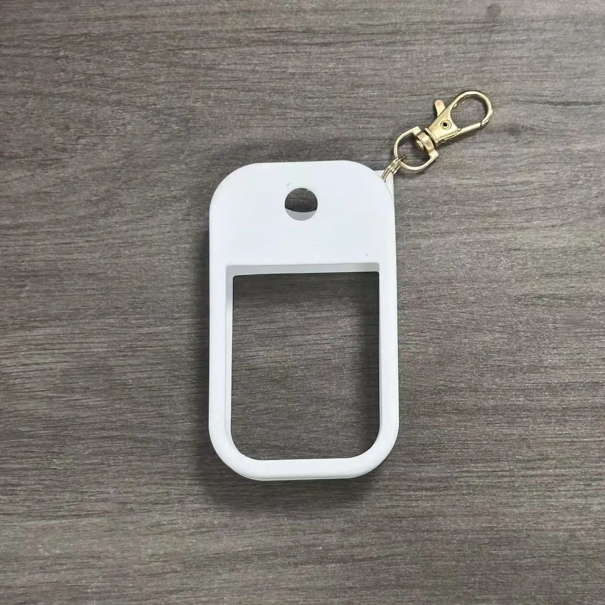 White silicone protective case for a hand sanitizer spray attached to a gold-colored keyring