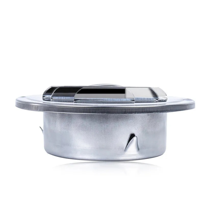 A round stainless steel ventilation grille with a glass cover.