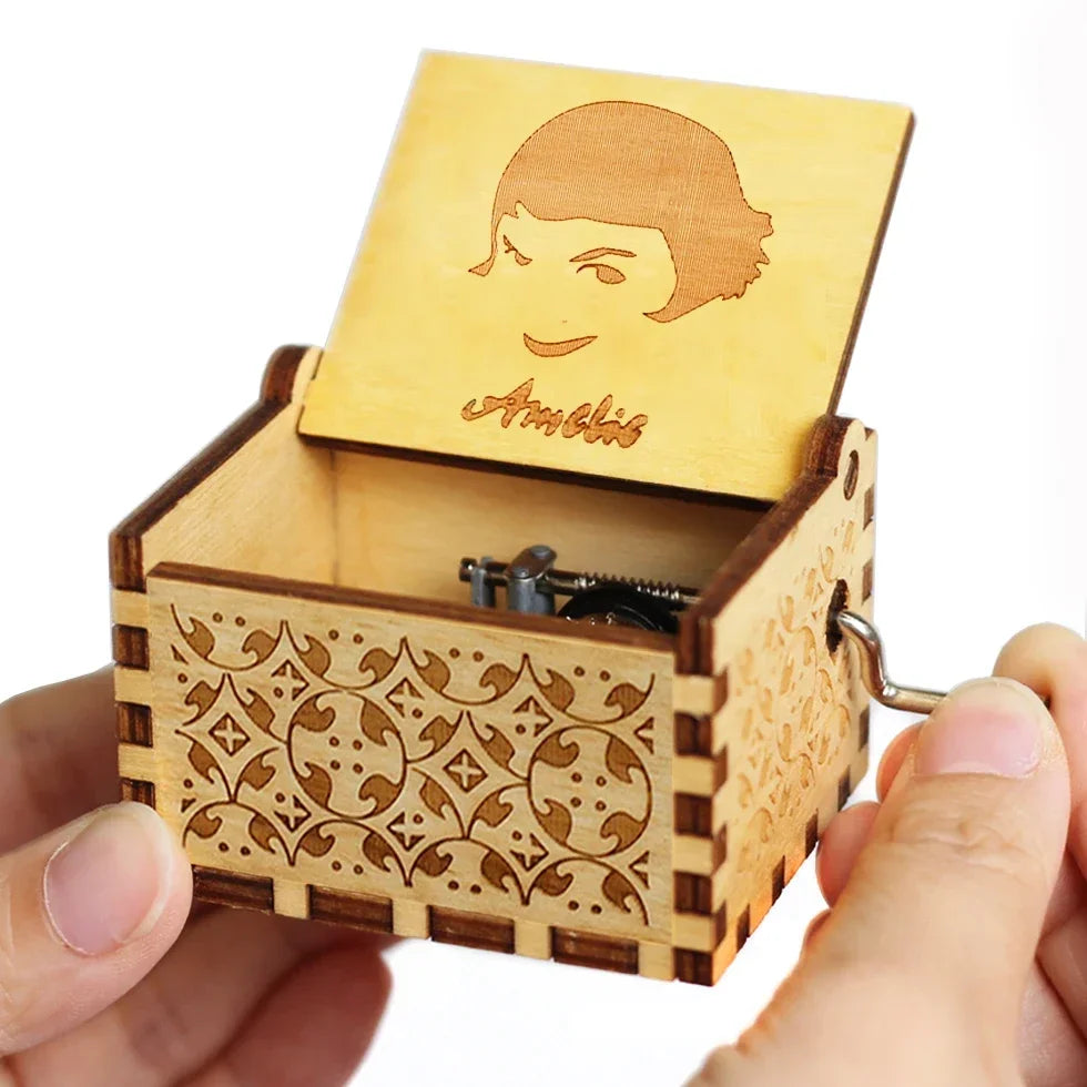 A wooden music box with a lid featuring a face design is held in a hand.