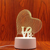 A clear wireframe heart sculpture light display on a white base.