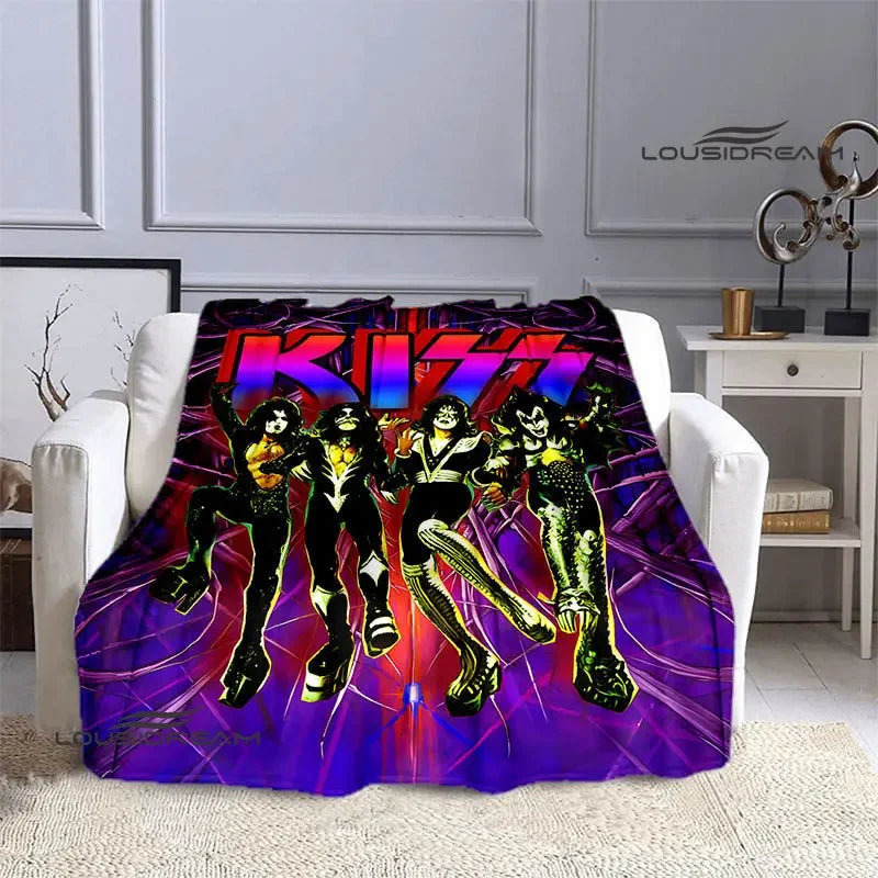 A purple and pink printed flannel throw blanket featuring the Kiss band members in dynamic poses.