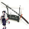 A miniature replica of a Demon Slayer katana sword with a decorative hilt and a figure inspired by Tanjiro.