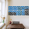 A decorative border design featuring blue and black Greek key patterns on a wall.