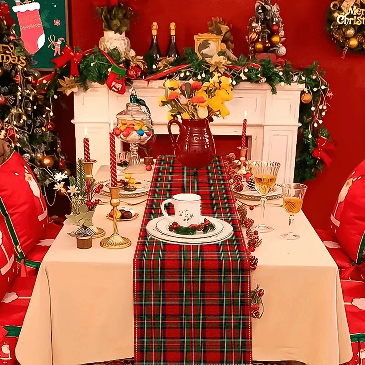 A festive holiday table setting featuring a tartan Christmas table runner on a white tablecloth with decorations and a firepl