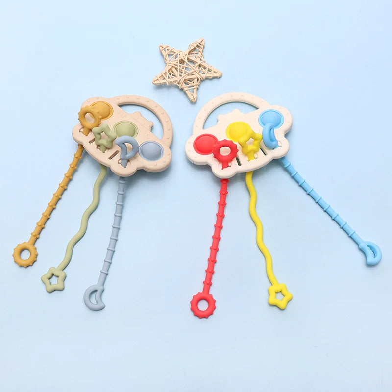 A silicone bear teether with a textured pull string and a star-shaped silicone toy on a light blue background.