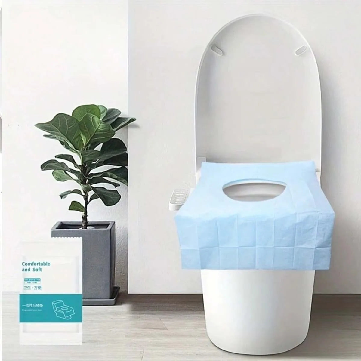 A white toilet seat with a light blue disposable liner placed on top, shown in a bathroom setting.