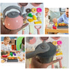 A hand holds a pink pot and pan set with various colorful pretend food items for kids play.