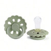 A silicone baby pacifier with a light green, flower-shaped silicone ring and a clear silicone nipple.