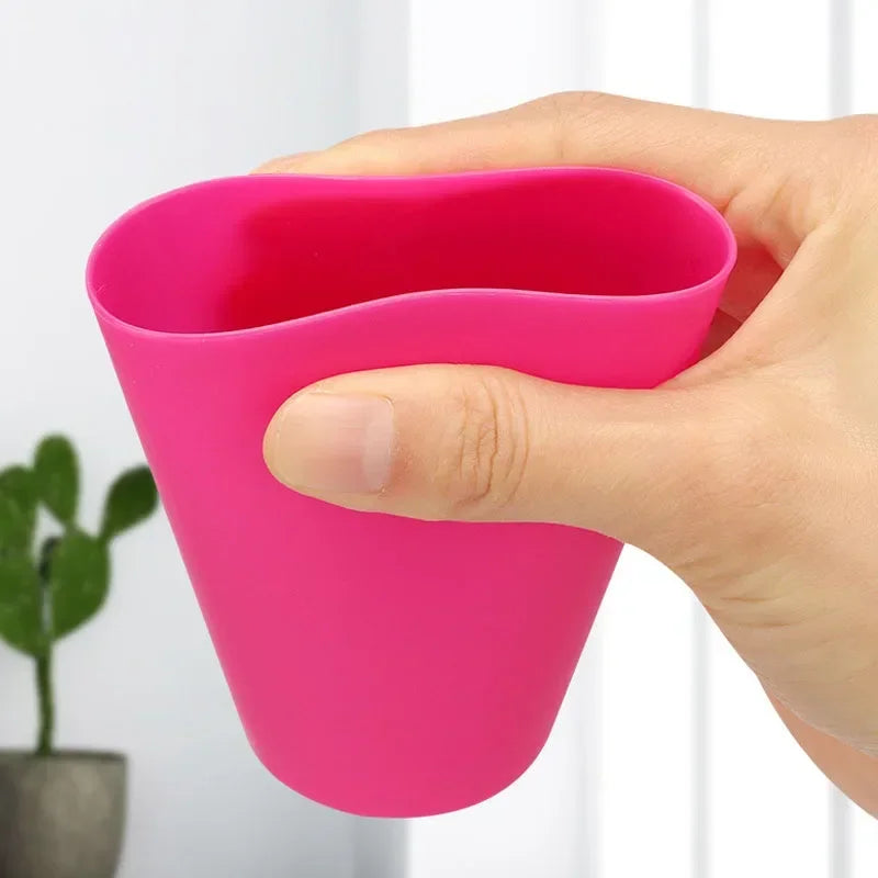 A hand holds a bright pink Montessori stack cup game with cards for children.