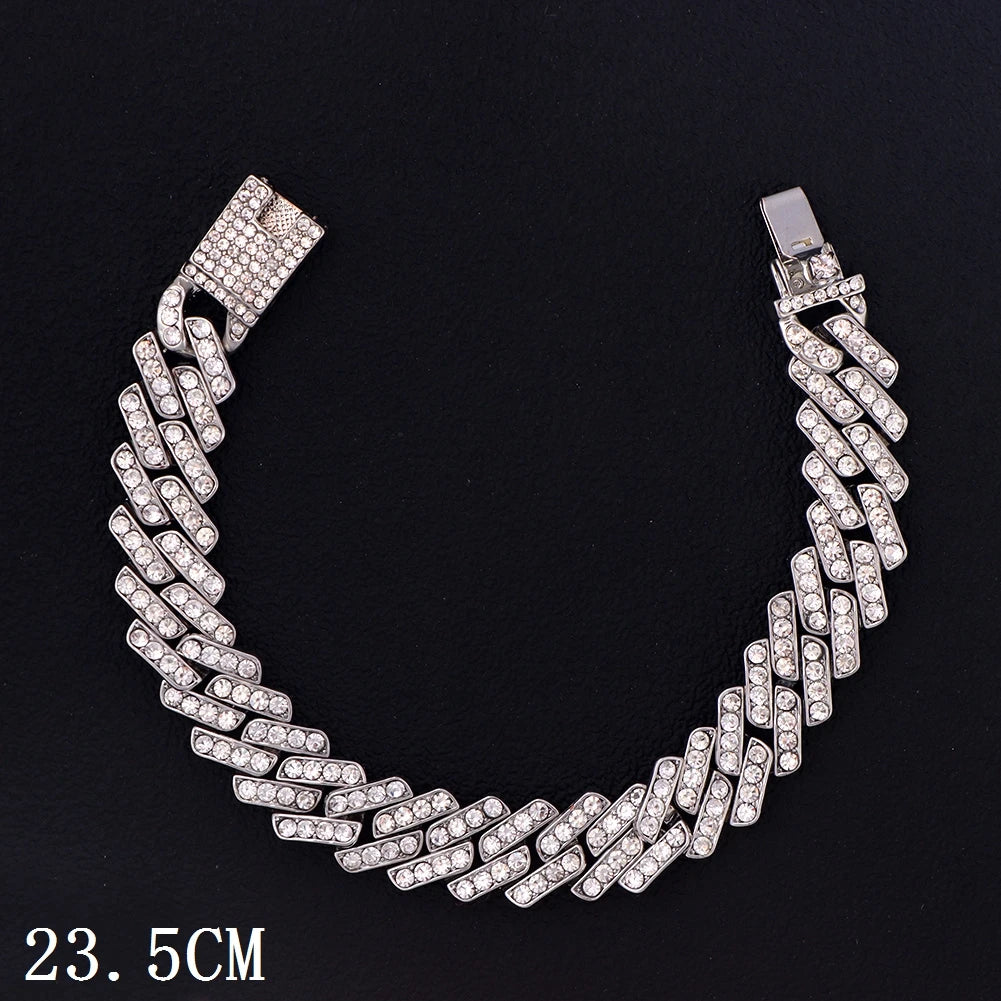A silver iced-out Cuban link anklet with a bail, shown against a black background.