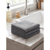 A stack of six gray waffle weave microfiber kitchen towels resting on a marble countertop near a white sink.