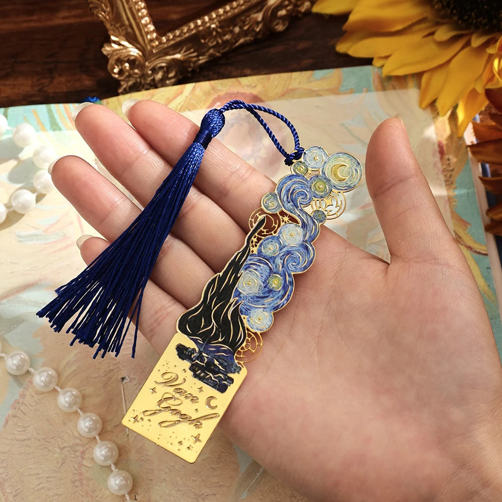 A hand holds a vintage metal bookmark with an artistic hollow design and blue enamel, featuring a dark silhouette and a blue 