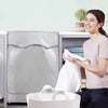 A woman is holding a white towel while sitting next to a gray waterproof washing machine cover.