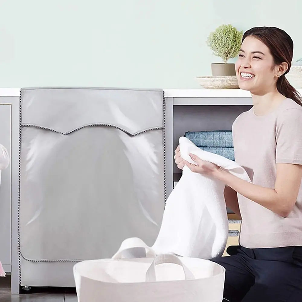 A woman is holding a white towel while sitting next to a gray waterproof washing machine cover.