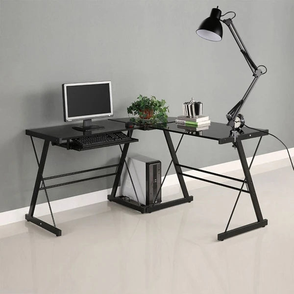 A black adjustable swing arm desk lamp mounted on a black metal desk frame with a computer monitor and books.