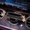 A crystal flower gravity car phone holder with auto-lock mounted on a car stereo panel.
