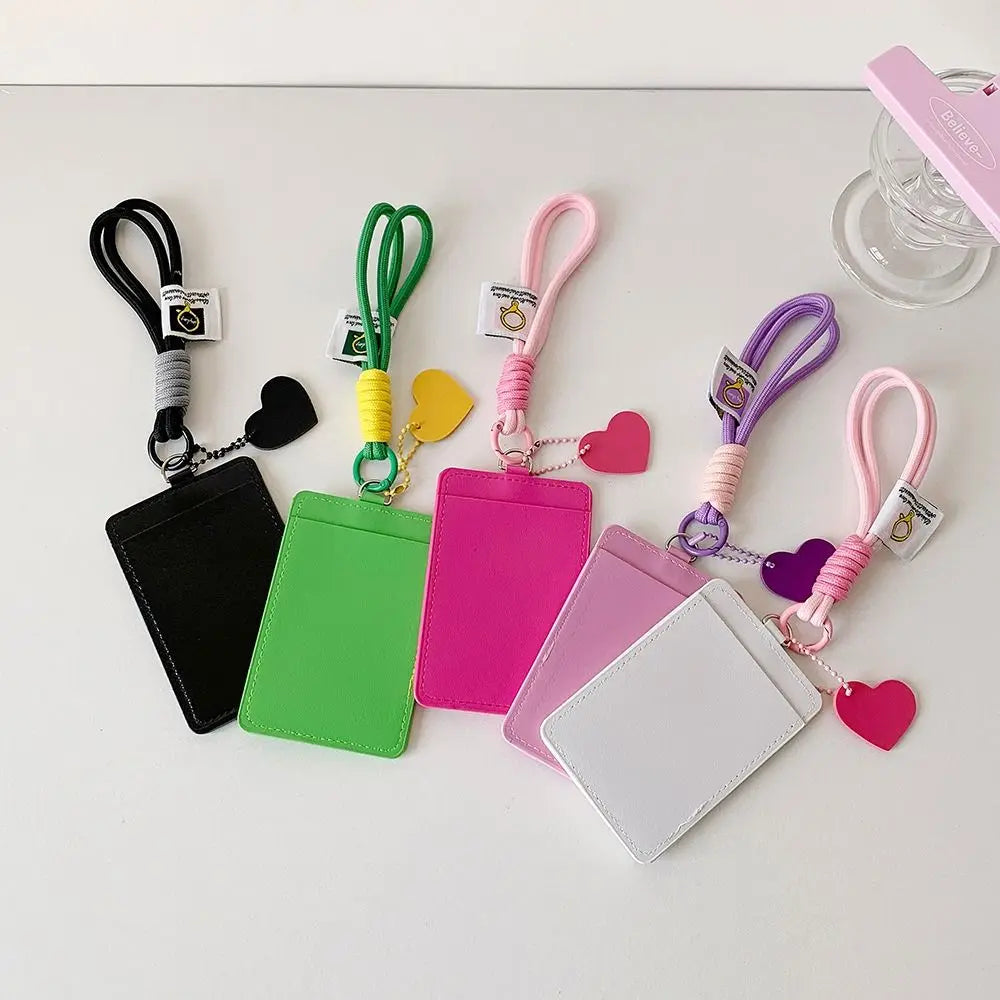 Eine Sammlung von rosa, grün und lila Kunstleder-Kartentfächern mit passenden Schlüsselbändern und Herzanhängern.