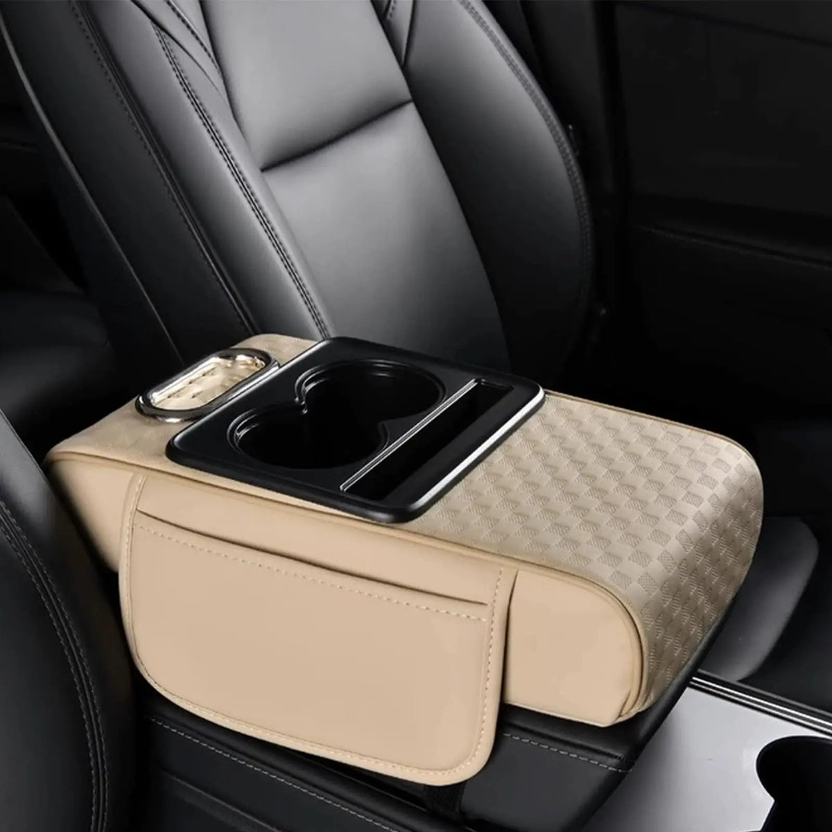 A beige car armrest cushion with a black cupholder and storage compartment is placed on a dark leather seat.