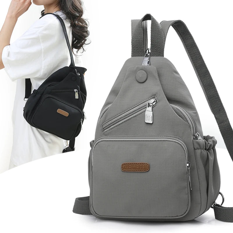 A gray waterproof nylon crossbody sling bag with a zipper and adjustable strap is shown against a white background.