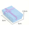 Light blue velvet jewelry gift box with a purple ribbon and cushioned insert
