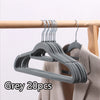Grey velvet non-slip hangers with hooks displayed on a wooden rod.