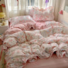 A pink floral duvet cover set with matching pillowcases and a flat sheet displayed on a bed.