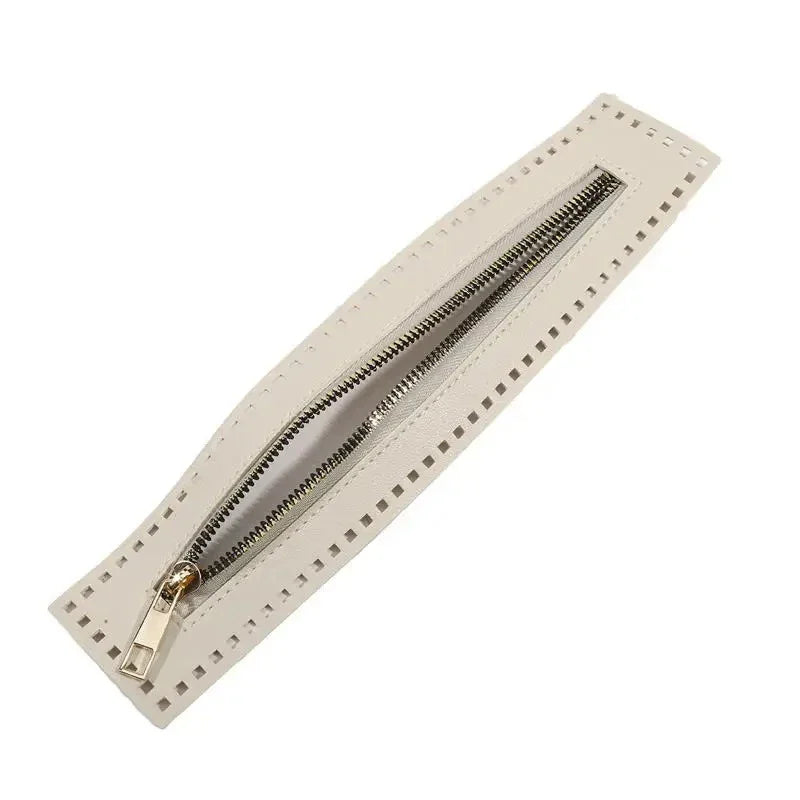 A beige leather zipper with a metal pull is shown diagonally against a white background.
