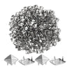 A pile of silver metal pyramid studs with four prongs for DIY fashion projects