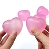 Pink heart-shaped stress relief squeeze toy being held in a hand