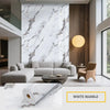 A modern living room featuring a sofa and coffee table against a white marble accent wall.