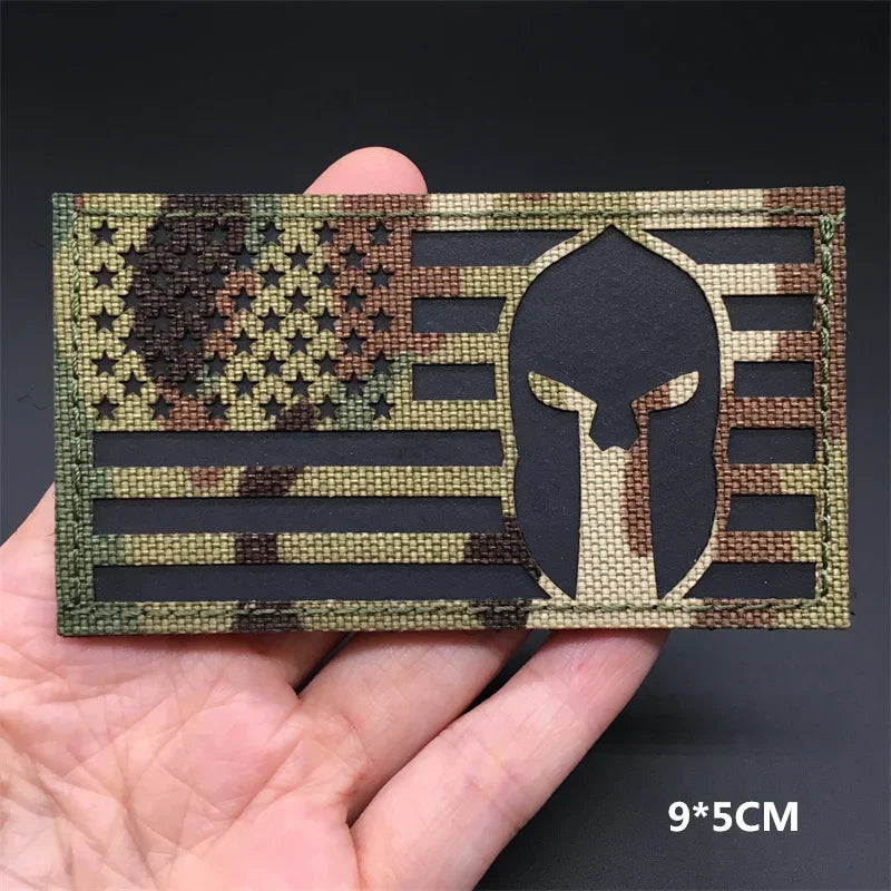 A rectangular tactical patch featuring a distressed American flag design with a silhouette of a Native American head.