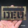 A dark camouflage tactical patch featuring the German flag design with hook-and-loop backing.