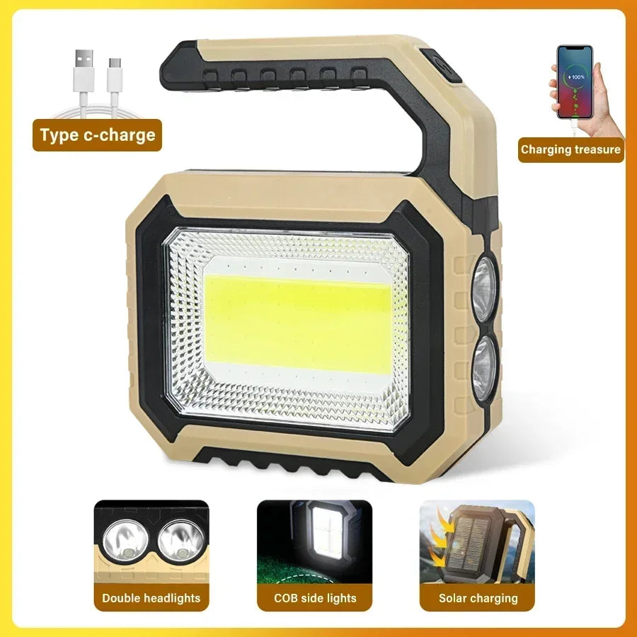 A beige and black solar-powered LED flashlight with a front light, double headlights, and USB-C charging port.