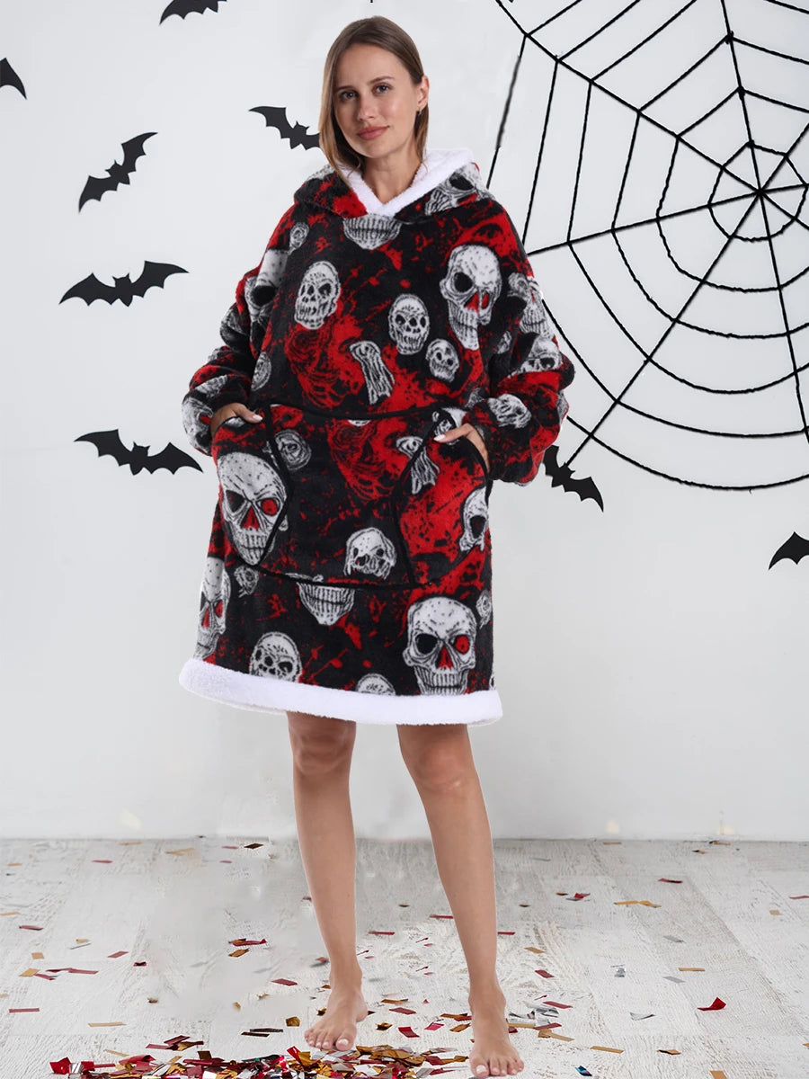 Eine Frau modelliert einen oversized Fleece-Hoodie mit Schädelmuster in schwarz und rot vor einer weißen Wand mit Spinnweben-