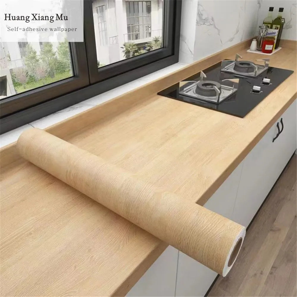 Roll of self-adhesive wood grain waterproof wallpaper displayed on a wooden countertop.