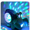 A glowing, blue-green crab toy with lights and music spinning in the air.