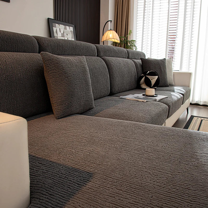 Cojín de asiento de sofá elástico gris moderno con tela texturizada y cojines decorativos en una sala de estar.